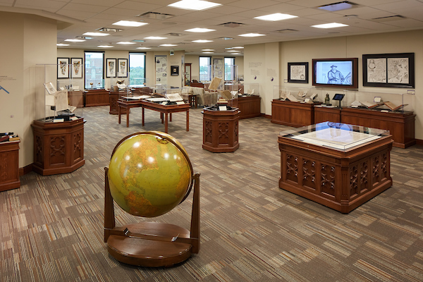 Exhibit space on the 5th floor of Bizzell. The area features several glass cases, tables, and a large globe.